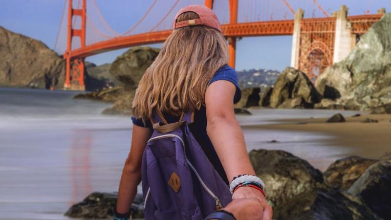 student walking toward bridge